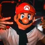 a man in a mario costume poses for a picture